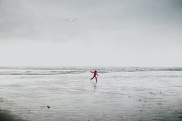 Mid distance of girl running on beach against sky - CAVF20467
