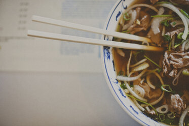 Overhead view of noodles soup served in bowl on table - CAVF20480