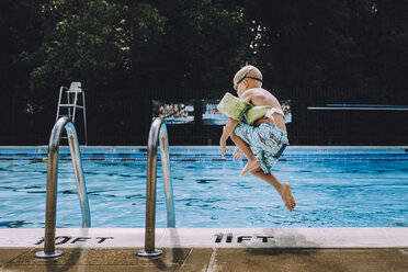 Carefree boy jumping into swimming pool - CAVF20505