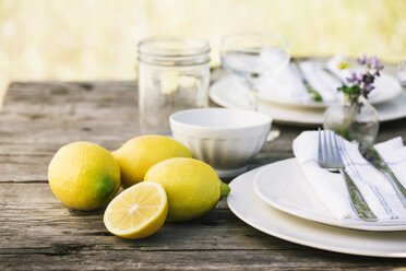 Nahaufnahme von Zitronen neben Tellern auf dem Tisch - CAVF20547