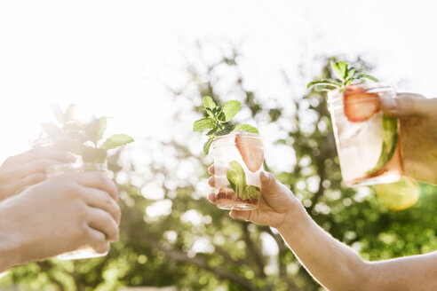 Cropped image of friends toasting mojito glasses at yard - CAVF20557