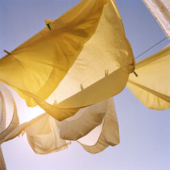 Niedriger Blickwinkel auf Wäsche, die an Wäscheleinen gegen den klaren Himmel hängt - CAVF20560