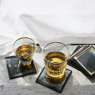 Hohe Winkelansicht von Whiskey-Gläsern auf dem Tisch durch einen Vorhang - CAVF20586
