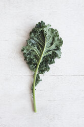 Overhead view of kale leaf on wooden table - CAVF20598