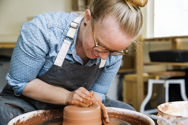 Happy woman molding clay on pottery wheel - CAVF20624