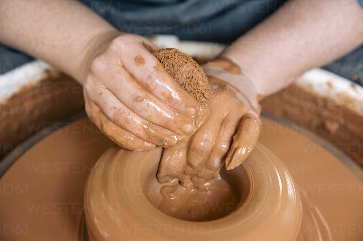 Close-up of woman's hands molding clay on wheel stock photo