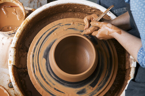 Cropped image of woman molding shape on pottery wheel - CAVF20633
