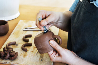 Woman working on earthenware at workshop - CAVF20639