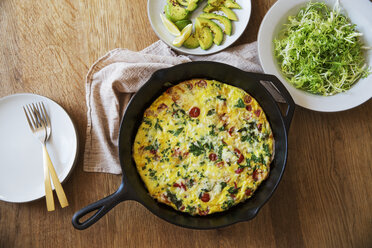 Overhead view of omelet in frying pan on wooden table - CAVF20757