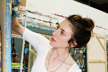 Junge Frau malt auf Leinwand in einem Kunstatelier - CAVF20813