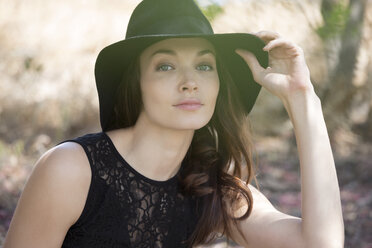 Portrait of beautiful woman wearing black hat and dress - CAVF20863