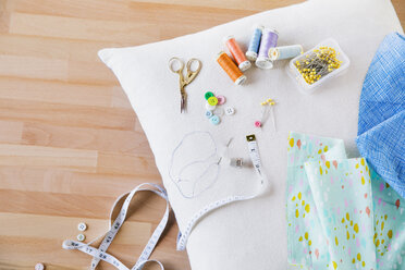 Overhead view of sewing item on pillow at table - CAVF21002