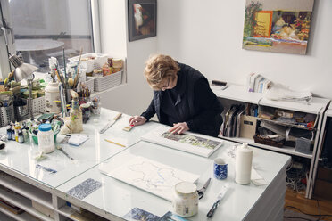 High angle view of senior woman drawing on table - CAVF21071