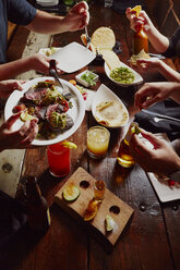 Ausgeschnittenes Bild von Menschen beim Essen am Tisch - CAVF21156