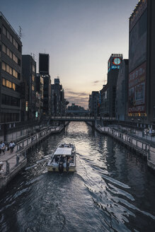 Boot im Dotonbori-Kanal inmitten von Gebäuden in der Stadt - CAVF21168