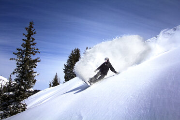 Low angle view of man snowboarding on snow covered mountain - CAVF21947