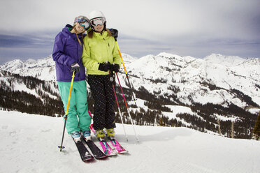 Glückliche Freunde beim Skifahren auf einem schneebedeckten Feld vor den Bergen - CAVF21953