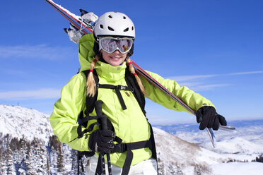 Glückliche Frau mit Skiern auf einem schneebedeckten Berg gegen den Himmel - CAVF21964