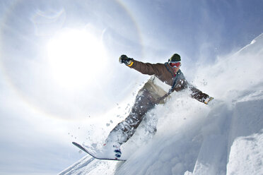Mann Snowboarding auf Berg gegen Himmel an sonnigem Tag - CAVF21969