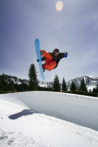 Mann Snowboarding auf Berg gegen Himmel, lizenzfreies Stockfoto