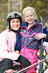 Porträt einer lächelnden Mutter und Tochter mit Skiern - CAVF22000
