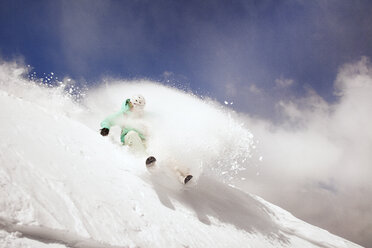 Low angle view of woman skiing on snow covered mountain against sky - CAVF22003