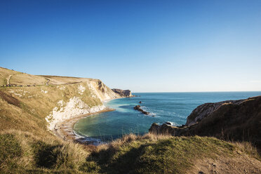 Scenic view of sea and cliffs against clear blue sky - CAVF22060