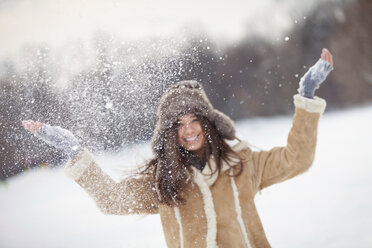 Portrait of excited woman playing with snow - CAVF22083