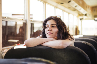 Nachdenkliche junge Frau sitzt in altem Bus - CAVF22130