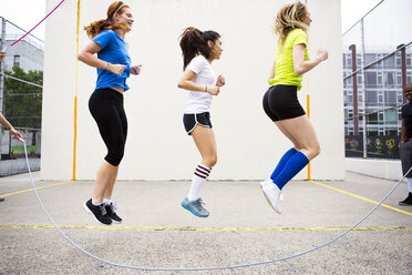 Seitenansicht von Frauen beim Double Dutch gegen die Wand - CAVF22191