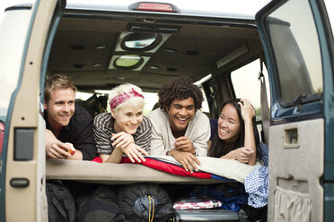 Happy friends lying in back of camping van - CAVF22226