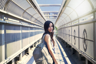 Portrait of woman standing at covered walkway on sunny day - CAVF22350