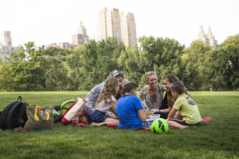 Familie und Freunde genießen ein Picknick im Park der Stadt - CAVF22374