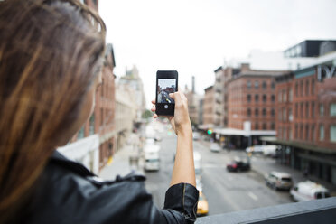 Ausgeschnittenes Bild einer Frau, die mit ihrem Mobiltelefon die Stadt fotografiert - CAVF22388