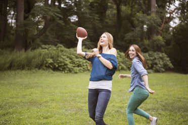 Freundinnen spielen Fußball auf einer Wiese - CAVF22415