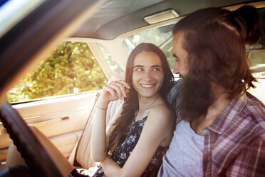 Happy couple looking at each other while sitting in pick-up truck - CAVF22445