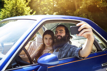 Couple taking selfie while sitting in pick-up truck - CAVF22446