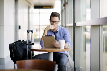 Geschäftsmann arbeitet an einem Tablet-Computer, während er in der Cafeteria einer U-Bahn-Station sitzt - CAVF22521