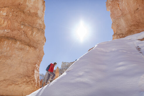 Hiker walking on snow covered mountain at Bryce Canyon National Park during sunny day - CAVF22569