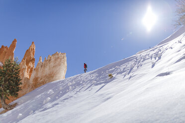Low-Winkel-Ansicht von Wanderer zu Fuß auf schneebedeckten Berg gegen den Himmel bei sonnigem Tag - CAVF22571