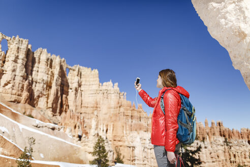 Low angle view of hiker photographing through mobile phone at Bryce Canyon National Park - CAVF22572