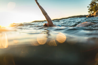 Sorglose Frau schwimmt im Meer gegen den Himmel - CAVF22625