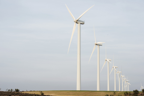 Windkraftanlagen auf einem Feld bei klarem Himmel, lizenzfreies Stockfoto