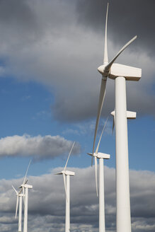 Niedriger Blickwinkel auf Windturbinen vor bewölktem Himmel - CAVF22640