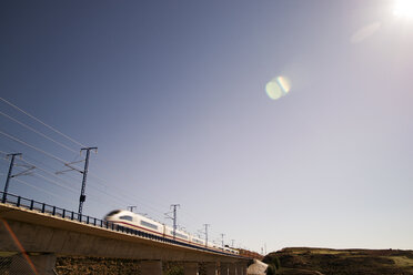 Hochgeschwindigkeitszug auf einer Eisenbahnbrücke bei klarem Himmel - CAVF22681