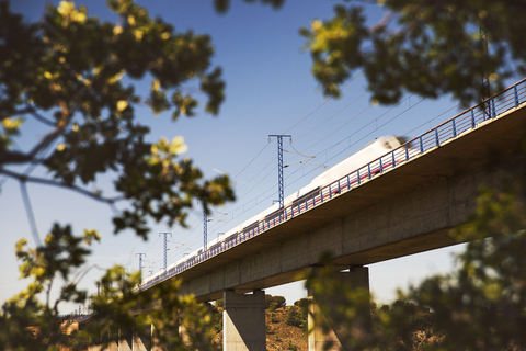 Low angle view of high speed train on railway bridge against clear sky, lizenzfreies Stockfoto