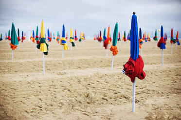 Geschlossene Sonnenschirme auf Sand am Strand - CAVF22693