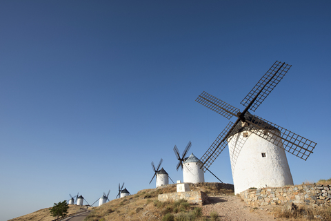 Low angle view of windmills in row against clear sky stock photo