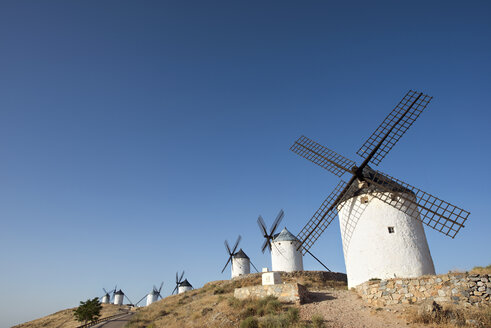 Low angle view of windmills in row against clear sky - CAVF22698