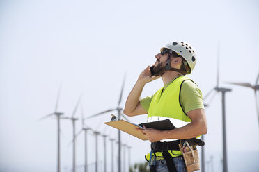 Engineer using smart phone at wind farm - CAVF22700